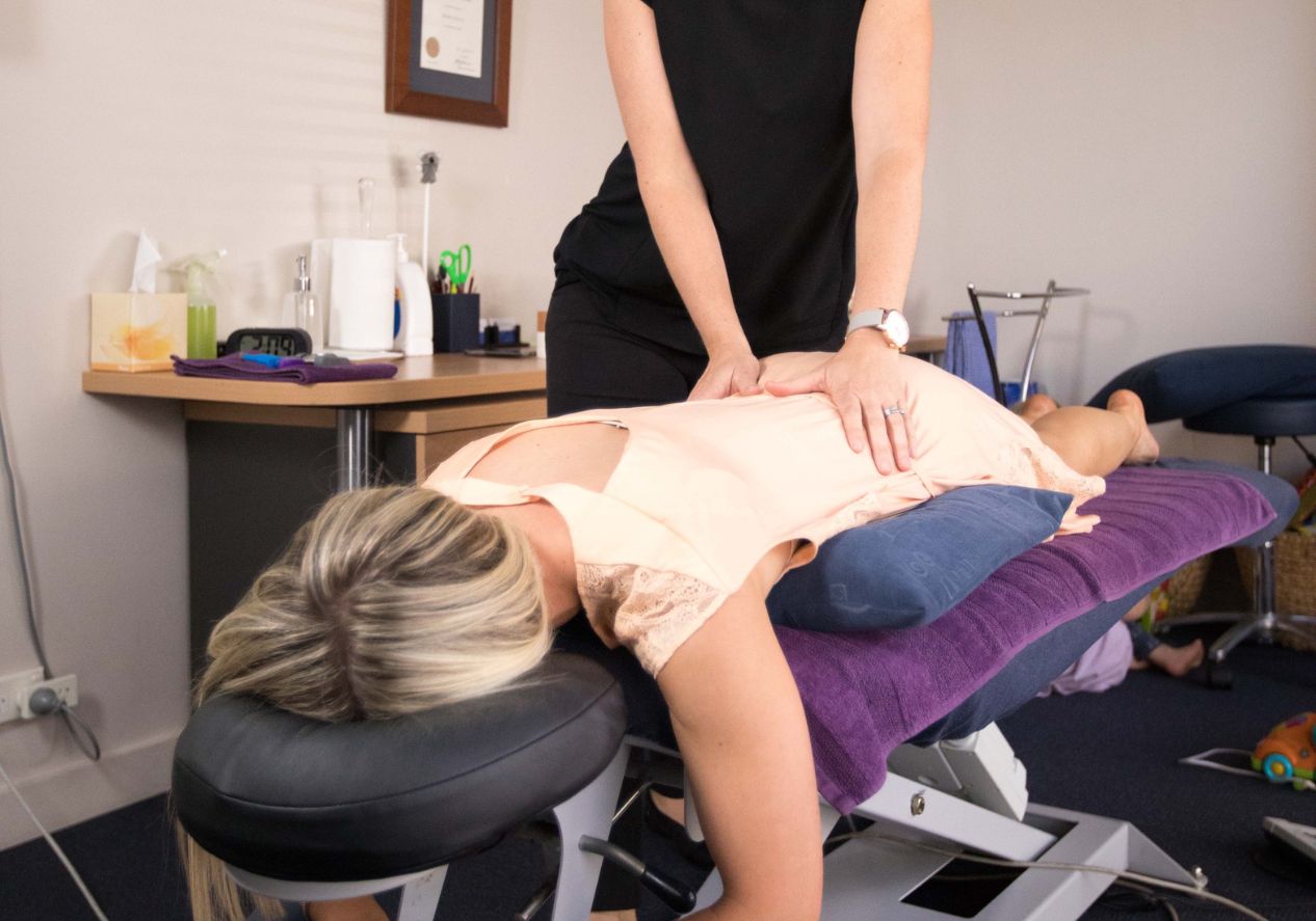 female chiropractor providing lower back adjustment